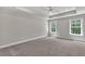 A spacious bedroom featuring neutral carpet, two windows and a ceiling fan at 2413 Malster Ln, Lawrenceville, GA 30043
