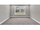 Bedroom with carpeting featuring two windows and neutral colors, creating a relaxing and inviting space at 2413 Malster Ln, Lawrenceville, GA 30043