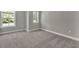 A bright bedroom featuring neutral walls and carpet with windows allowing natural light at 2413 Malster Ln, Lawrenceville, GA 30043