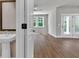 Hallway with pedestal sink and entry to a living room featuring hardwood floors and natural lighting at 2413 Malster Ln, Lawrenceville, GA 30043