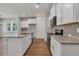 Open concept kitchen with granite countertops, stainless steel appliances, and tile backsplash at 2413 Malster Ln, Lawrenceville, GA 30043