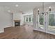 Open concept living room featuring a fireplace, ceiling fan, and views of the backyard at 2413 Malster Ln, Lawrenceville, GA 30043
