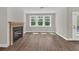 Bright living room featuring a modern fireplace, hardwood floors, large windows, and a ceiling fan at 2413 Malster Ln, Lawrenceville, GA 30043