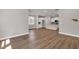 Open-concept living area flows into kitchen with white cabinetry and modern appliances over hardwood floors at 2413 Malster Ln, Lawrenceville, GA 30043