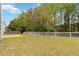 Large backyard with a well-maintained lawn, white fence, and plenty of trees for added privacy at 3791 Plantation Mill Dr, Buford, GA 30519