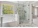 Modern bathroom features a soaking tub and frameless glass shower with beautiful black veined marble tile at 3791 Plantation Mill Dr, Buford, GA 30519