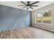 Serene bedroom with eye-catching accent wall, modern ceiling fan, and large window offering ample natural light at 3791 Plantation Mill Dr, Buford, GA 30519