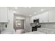 Modern kitchen showcases stainless steel appliances, white cabinets and a view to the dining area at 3791 Plantation Mill Dr, Buford, GA 30519