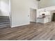 Open-concept living room featuring hardwood floors and a seamless transition to the kitchen and stairway at 3791 Plantation Mill Dr, Buford, GA 30519