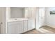 Bathroom featuring dual vanities, framed mirrors, and white cabinetry at 1022 Sutherland Lane (Lot 42), Lawrenceville, GA 30043