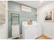 Functional laundry room with a washer, dryer, and shelving for storage and decorated with cozy signage at 1022 Sutherland Lane (Lot 42), Lawrenceville, GA 30043