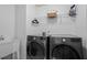 Bright laundry room featuring a white utility sink, and modern washer and dryer at 331 Spotted Ridge Cir, Woodstock, GA 30188
