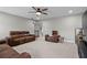 Open living room area with carpet, brown leather couches, and a ceiling fan at 331 Spotted Ridge Cir, Woodstock, GA 30188