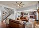 Open-concept living room showcases staircase, leather sofas, hardwood floors, and access to the kitchen at 331 Spotted Ridge Cir, Woodstock, GA 30188
