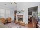 Cozy living room with a stone fireplace, hardwood floors, comfortable armchairs and natural light at 331 Spotted Ridge Cir, Woodstock, GA 30188