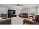 Spacious living room featuring comfortable leather sofas, a ceiling fan, and a large TV at 331 Spotted Ridge Cir, Woodstock, GA 30188