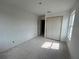 A bright bedroom with a closet and a window, showcasing fresh paint and unfinished flooring at 5114 Arista Dr, Douglasville, GA 30135