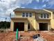 A newly constructed yellow townhome with an attached garage and a partially landscaped yard at 5114 Arista Dr, Douglasville, GA 30135