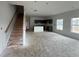 Unfinished living room featuring many large windows with an attached kitchen and a staircase to the upper floor at 5114 Arista Dr, Douglasville, GA 30135