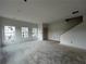 Unfinished living room featuring many large windows, white walls, and an unfinished staircase to the upper floor at 5114 Arista Dr, Douglasville, GA 30135