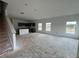 Unfinished living room featuring many large windows with an attached kitchen and a staircase to the upper floor at 5114 Arista Dr, Douglasville, GA 30135