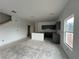 Unfinished living room featuring many large windows with an attached kitchen featuring gray cabinets and a staircase at 5114 Arista Dr, Douglasville, GA 30135