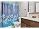 Bathroom featuring a toilet, vanity with sink and shower with vibrant blue patterned curtain at 527 Mossycup Dr, Fairburn, GA 30213