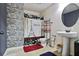 Bathroom with stone accent wall, pedestal sink, and black/white paris themed shower curtain at 527 Mossycup Dr, Fairburn, GA 30213