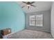 Empty bedroom with a bright accent wall, a ceiling fan, and a window at 527 Mossycup Dr, Fairburn, GA 30213