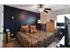 Bedroom with a dark accent wall, ceiling fan, and a window at 527 Mossycup Dr, Fairburn, GA 30213