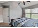 Bedroom with a large window offering views and a ceiling fan for comfortable climate control at 527 Mossycup Dr, Fairburn, GA 30213
