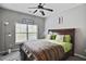 Comfortable bedroom featuring a ceiling fan, large window and warm decorative touches at 527 Mossycup Dr, Fairburn, GA 30213