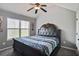 Cozy bedroom with a decorative headboard, ceiling fan, and window providing natural light at 527 Mossycup Dr, Fairburn, GA 30213
