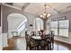 Charming dining room featuring hardwood floors, wainscoting, and arched doorways at 527 Mossycup Dr, Fairburn, GA 30213