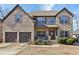 Charming two-story home featuring a brick facade, covered porch, and well-manicured landscaping at 527 Mossycup Dr, Fairburn, GA 30213
