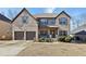Charming two-story home featuring a brick facade, covered porch, and well-manicured landscaping at 527 Mossycup Dr, Fairburn, GA 30213