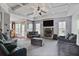Spacious living room featuring a stone fireplace, coffered ceilings, and stylish furnishings at 527 Mossycup Dr, Fairburn, GA 30213
