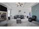 Spacious living room featuring a stone fireplace, coffered ceilings, and stylish furnishings at 527 Mossycup Dr, Fairburn, GA 30213