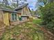 Exterior shot of backyard with patio, wooden fence, lush green space, and mature trees at 6301 Creekford Dr, Lithonia, GA 30058