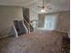 Spacious living room featuring plush carpeting, a ceiling fan, and access to the backyard at 6301 Creekford Dr, Lithonia, GA 30058