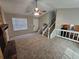 Bright living room with plush carpeting, a cozy fireplace, and a staircase leading to the upper level at 6301 Creekford Dr, Lithonia, GA 30058