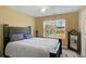 Bedroom with dark wood bed frame, ceiling fan, and natural light from window at 6880 Robinson St, Lithonia, GA 30058