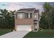 Charming two-story home featuring a brick and gray siding exterior, attached garage, and a well-manicured front yard at 1020 Sutherland Lane (Lot 43), Lawrenceville, GA 30043