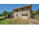 Rear view of home with a brick facade, a garage, and grassy yard at 1048 Tumblewood Trl, Lawrenceville, GA 30044