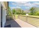 Large back porch with wood floors that overlooks a grassy back yard with mature trees at 12042 Brown Bridge Rd, Covington, GA 30016