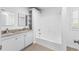 Bright bathroom features a double sink vanity with granite countertops and a shower-tub combo at 12042 Brown Bridge Rd, Covington, GA 30016