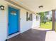 Close up of a bright blue front door with glass pane and brown pillars on a cozy front porch at 12042 Brown Bridge Rd, Covington, GA 30016