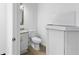 A clean half-bathroom featuring a granite vanity and white fixtures and a ceramic tile floor at 12042 Brown Bridge Rd, Covington, GA 30016