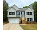 Charming two-story home features a two-car garage, traditional black shutters, and a classic gray and white color scheme at 48 Deer Pl, Villa Rica, GA 30180
