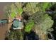 Aerial perspective reveals the home's green roof and boat dock surrounded by lush greenery and lakefront views at 480 Friar Tuck Cir, Covington, GA 30014
